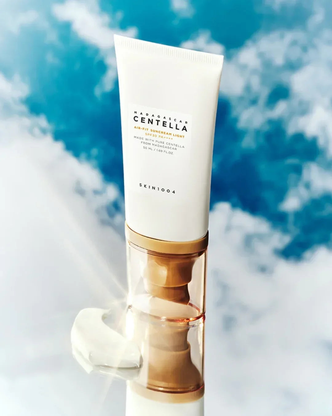 Madagascar Centella Air-Fit Suncream Light SPF30 PA++ tube with sunscreen cream on reflective surface and blue sky background