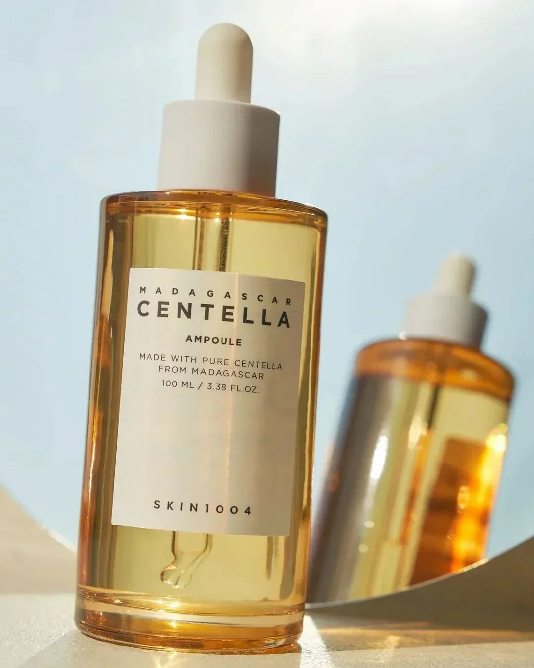 Madagascar Centella Ampoule skincare serum bottle with dropper, 100ml, studio shot with reflection