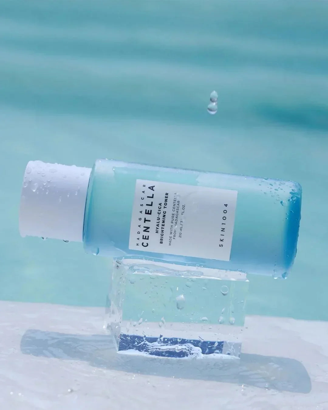 Madagascar Centella Hyalu-Cica Brightening Toner bottle on clear block with water droplets