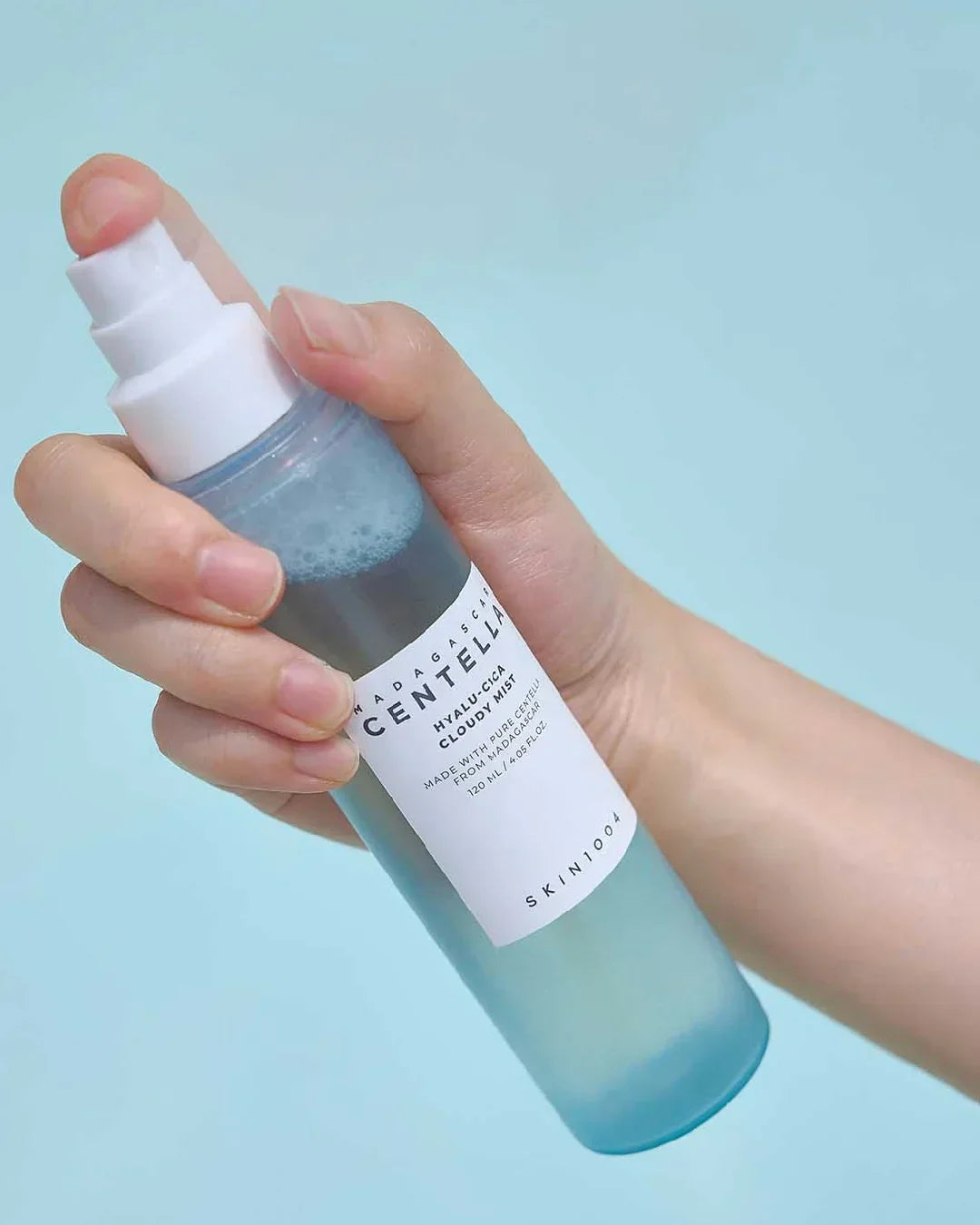 Hand holding Madagascar Centella Hyalu-Cica Cloudy Mist 120ml skincare spray bottle