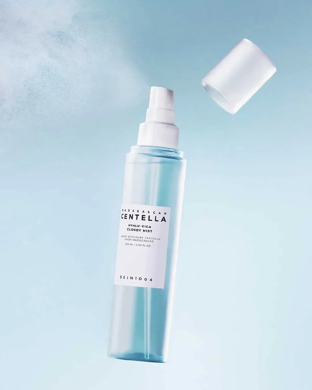 Skin1004 Madagascar Centella Hyalu-Cica Cloudy Mist spray bottle with cap floating against blue background
