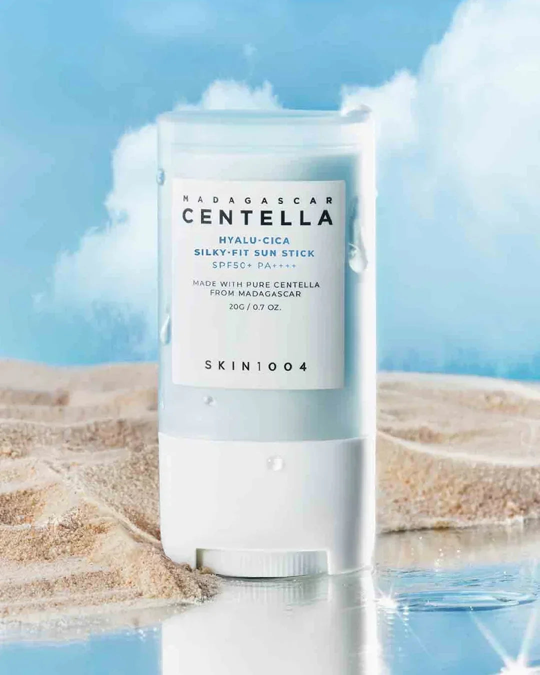 Skin1004 Madagascar Centella Hyalu-Cica Silky-Fit Sun Stick with SPF50+ on sandy beach with water drops