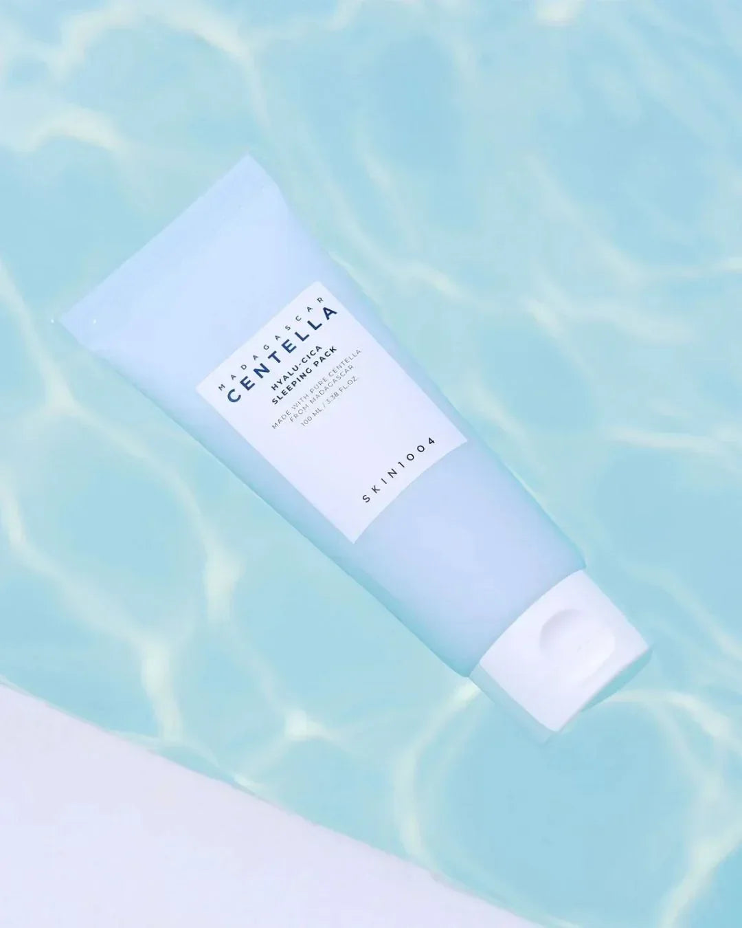 Skin1004 Madagascar Centella Hyalu-Cica Sleeping Pack tube floating on clear water surface