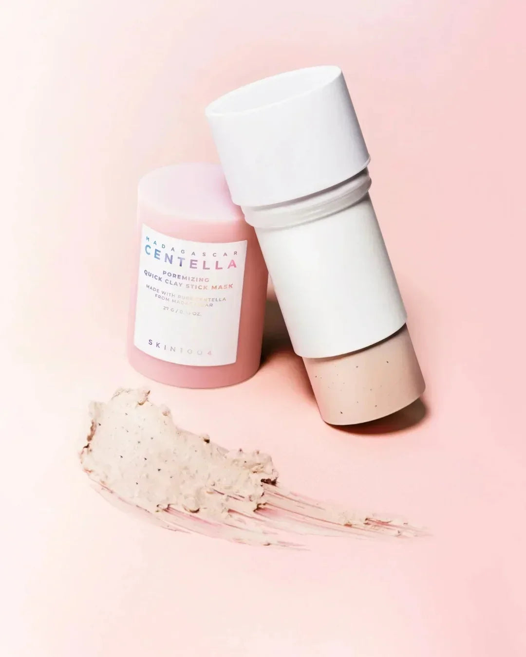 Madagascar Centella Poremizing Quick Clay Stick Mask by Skin1004 on pink background with clay texture smear