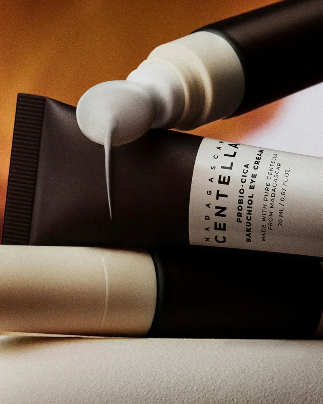Madagascar Centella ProBio-Cica Bakuchiol Eye Cream tube with cream flowing from applicator in studio setting