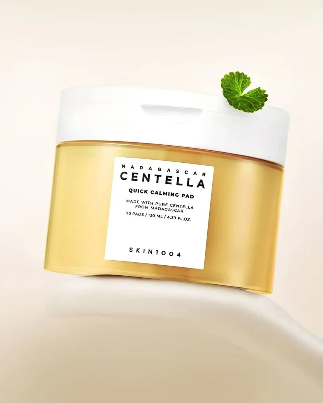 Skin1004 Madagascar Centella Quick Calming Pad jar with white lid and green leaf on beige background