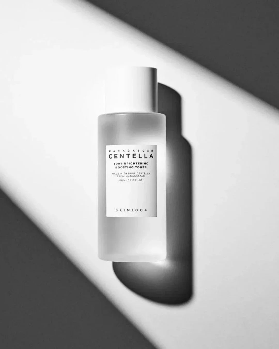 Madagascar Centella Tone Brightening Boosting Toner bottle casting shadow on white surface