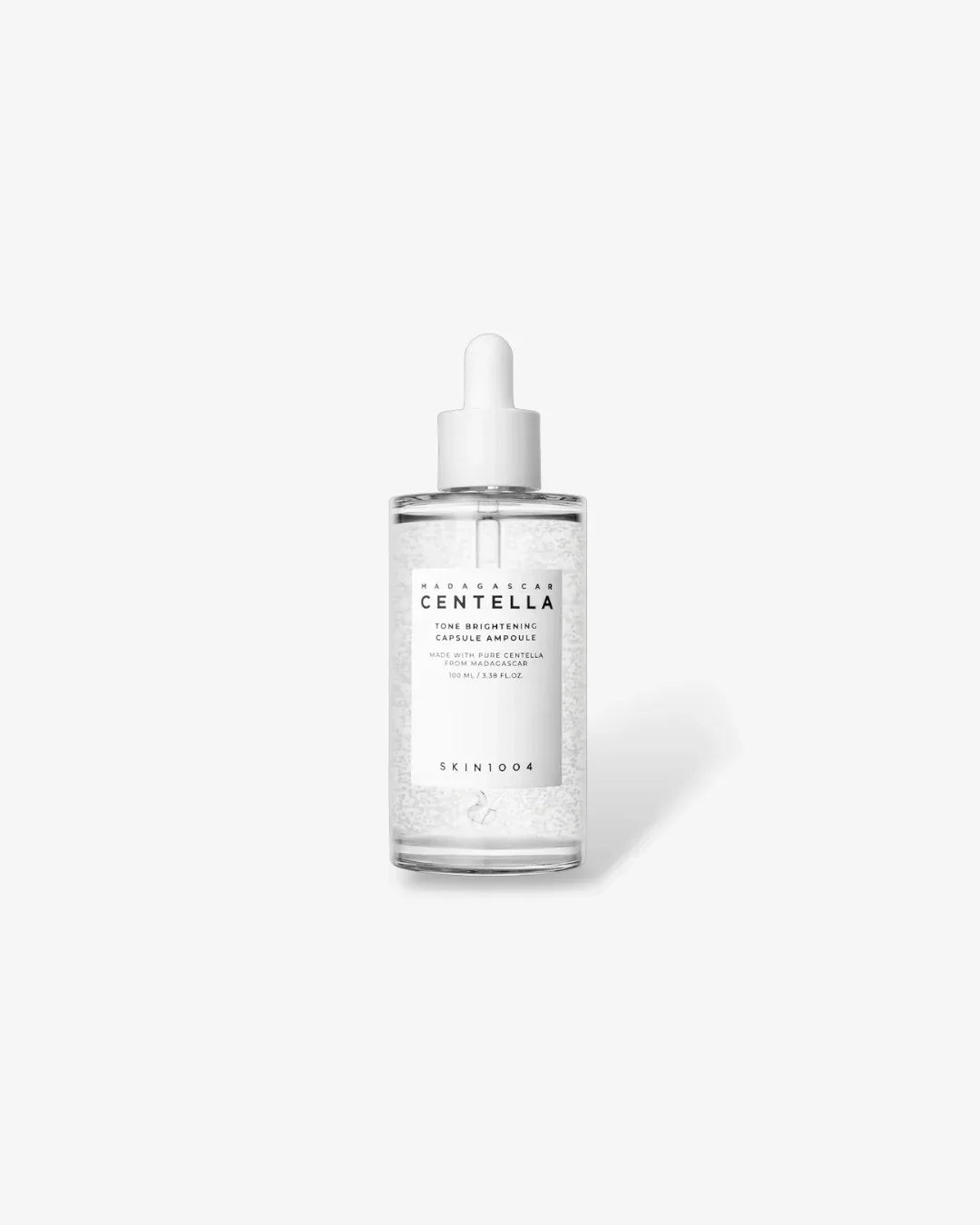 Clear glass bottle of Madagascar Centella Tone Brightening Capsule Ampoule with white dropper on white background