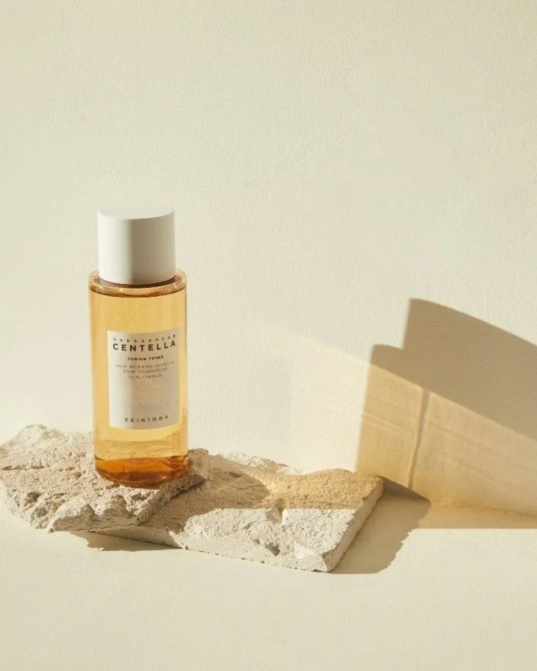 Madagascar Centella toning toner bottle on textured stone with soft natural light
