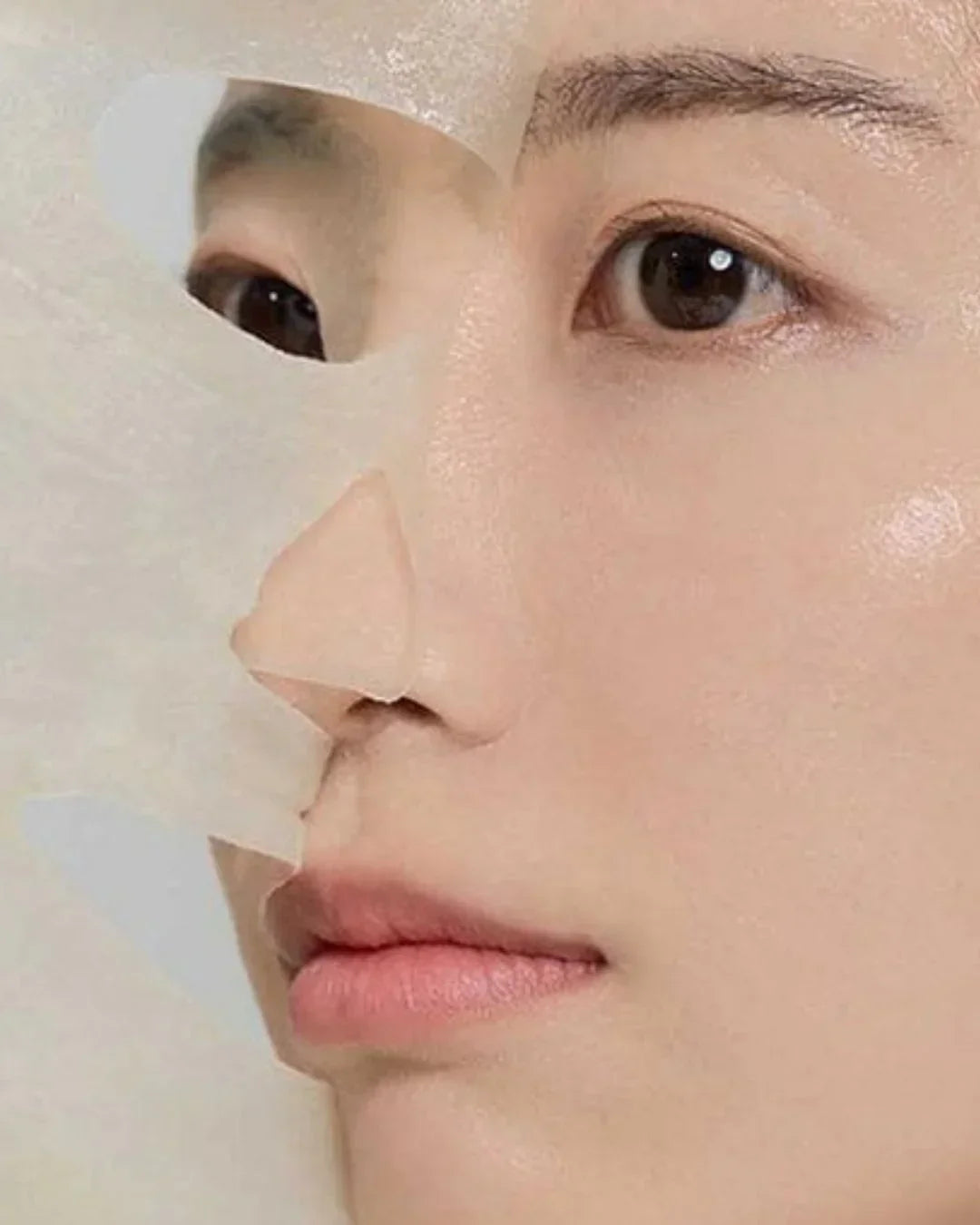 Close-up of person applying transparent sheet mask for skincare hydration and brightening