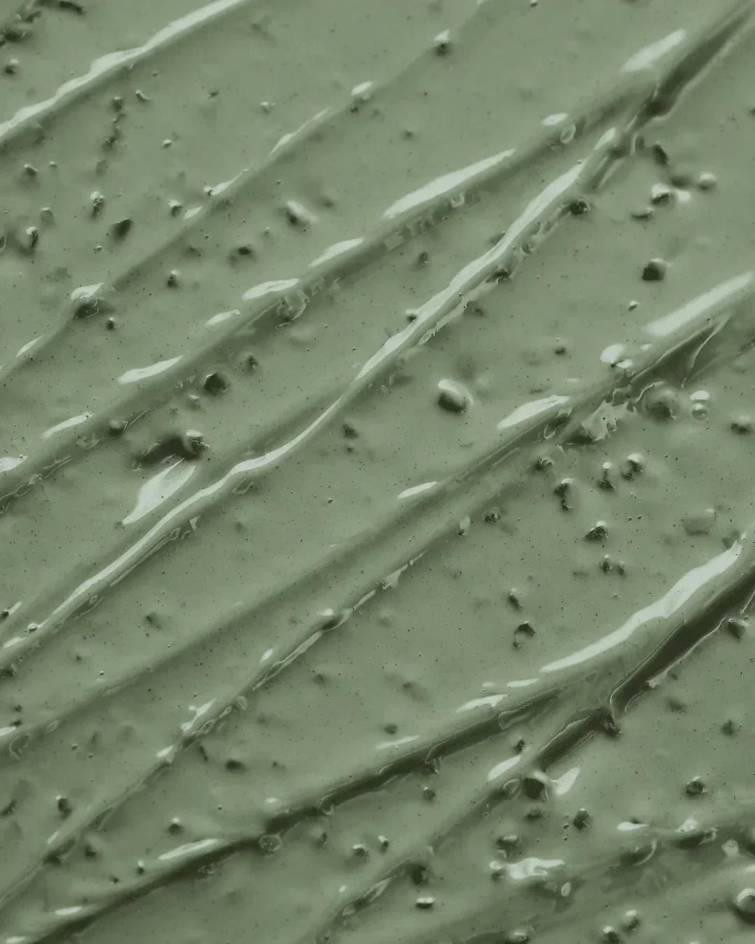 Close-up of green mugwort pore clarifying wash-off pack texture with smooth creamy consistency and small particles
