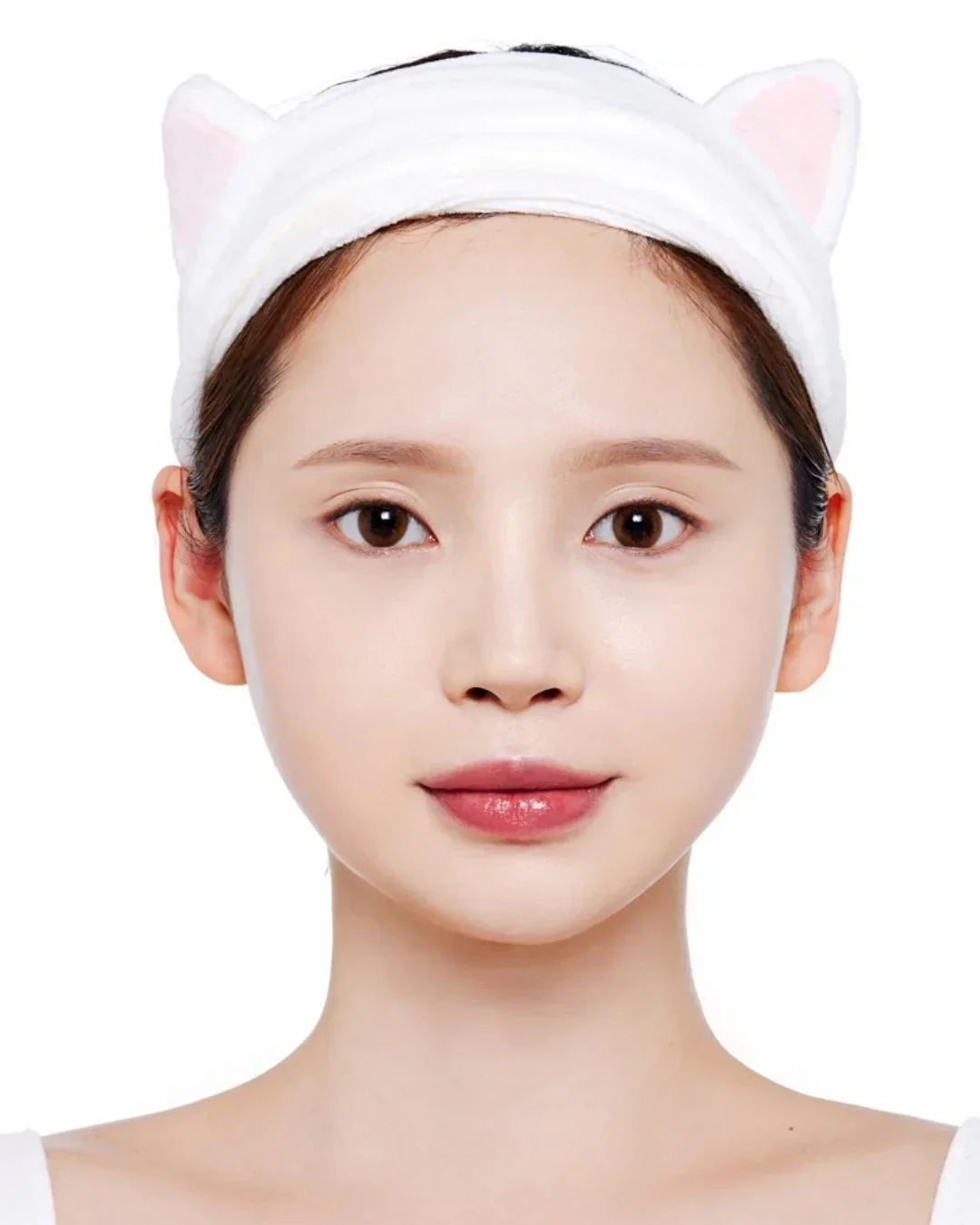 Close-up of woman wearing white cat ear hairband with clear skin on white background