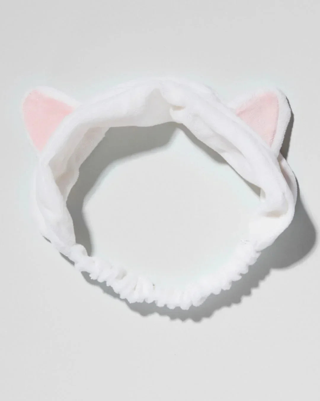 White plush hairband with pink inner cat ears on a light background