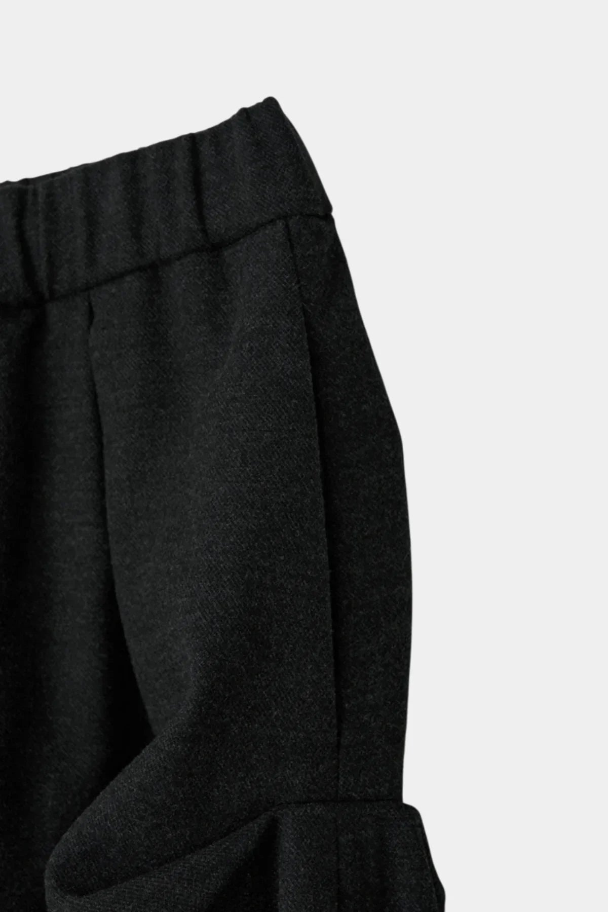 Close-up of charcoal Nest curtain skirt fabric with elastic waistband and textured weave
