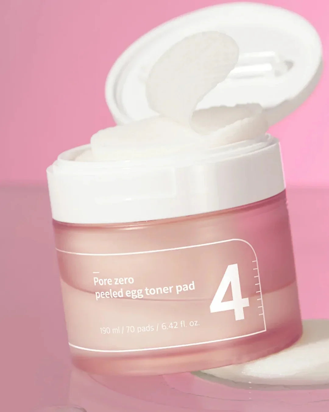 Open jar of Pore Zero Peeled Egg Toner Pads with white round pads, pink background