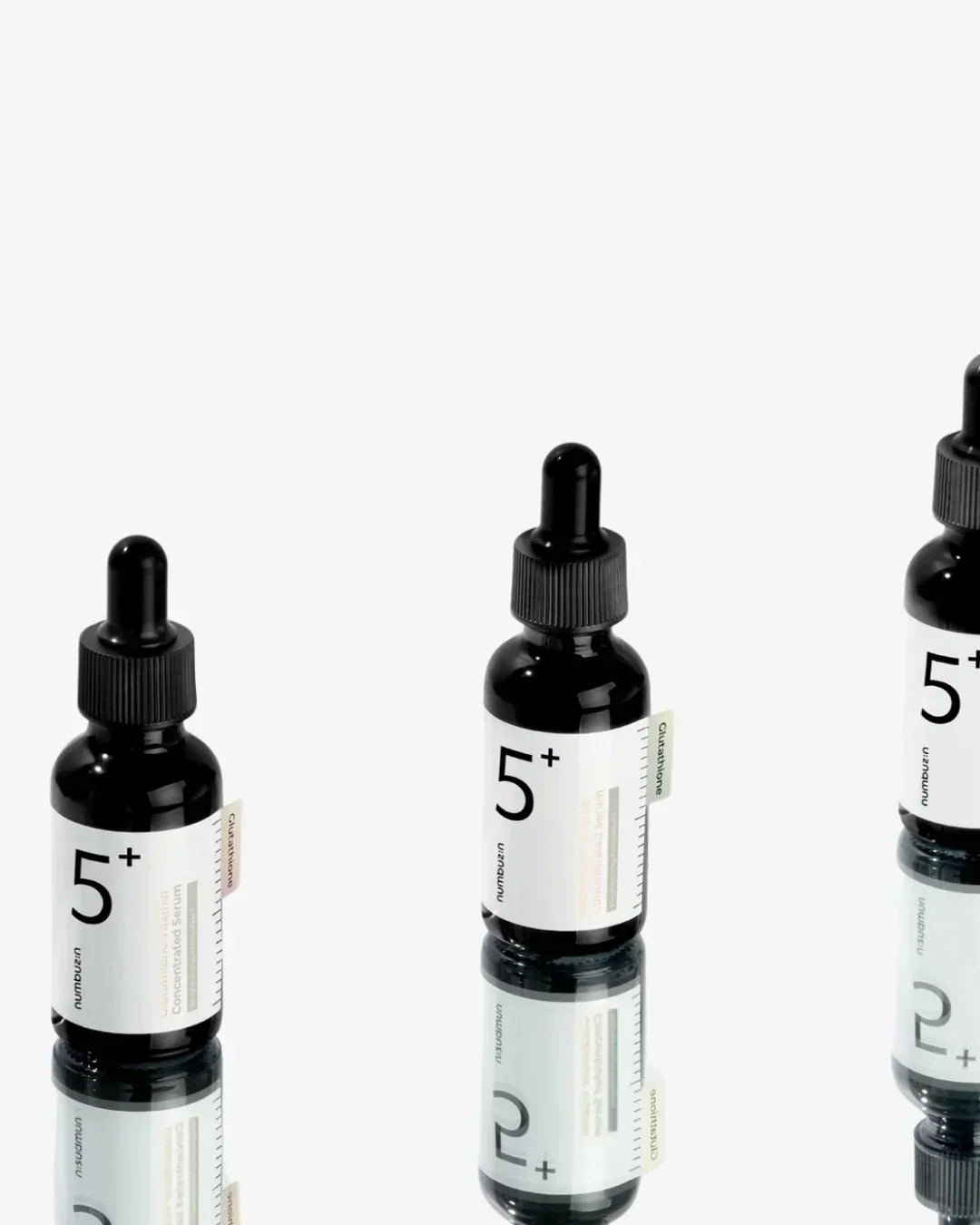 Numbuzin 5+ glutathione vitamin concentrated serum bottles with droppers on reflective surface