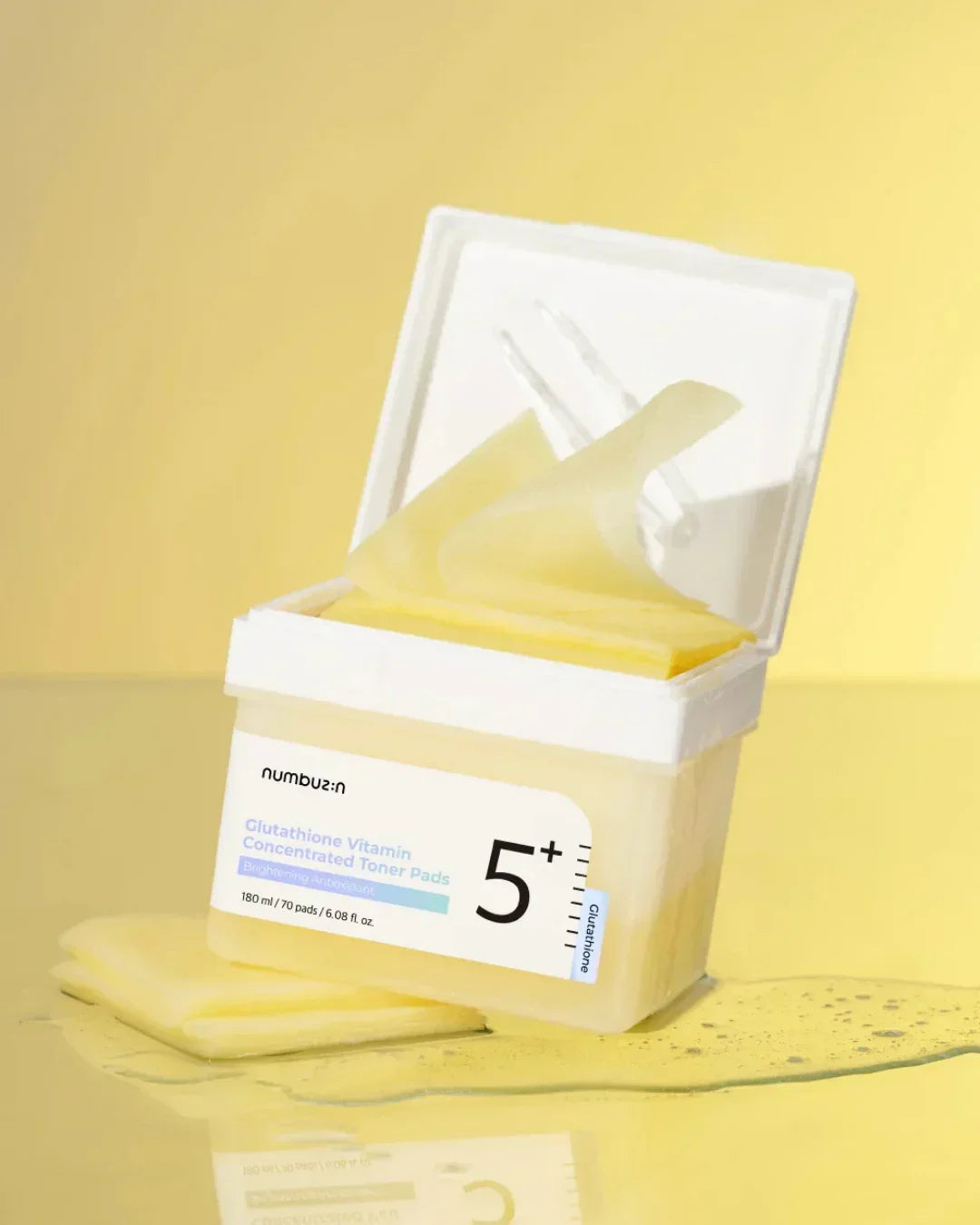 Open container of Glutathione Vitamin Concentrated Toner Pads with pale yellow pads on a yellow surface