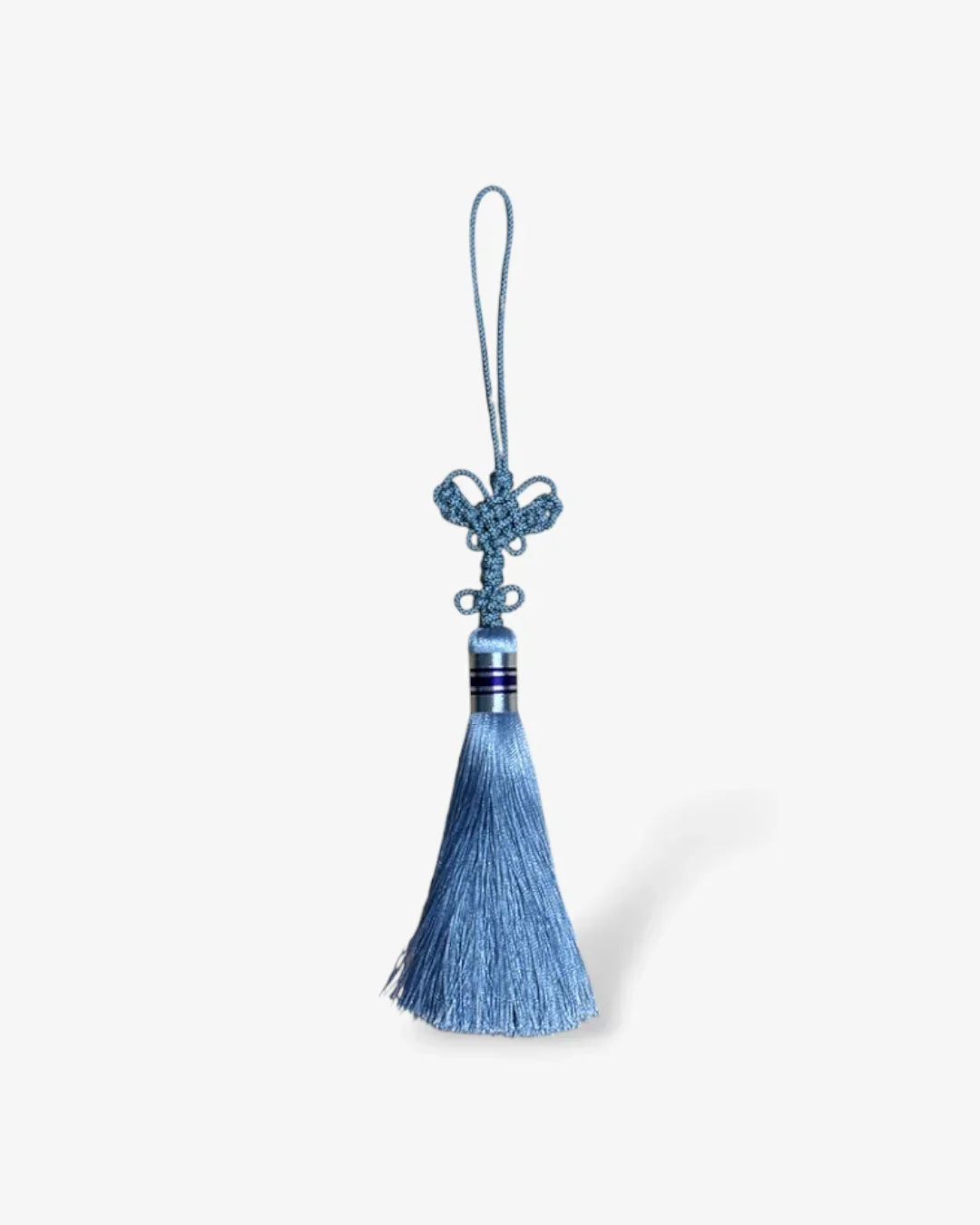 Blue decorative tassel with intricate knot and loop on white background