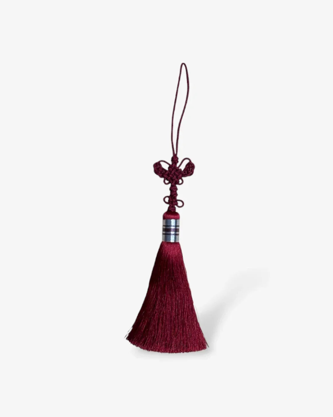 Red butterfly knot tassel with silver band and hanging loop on white background