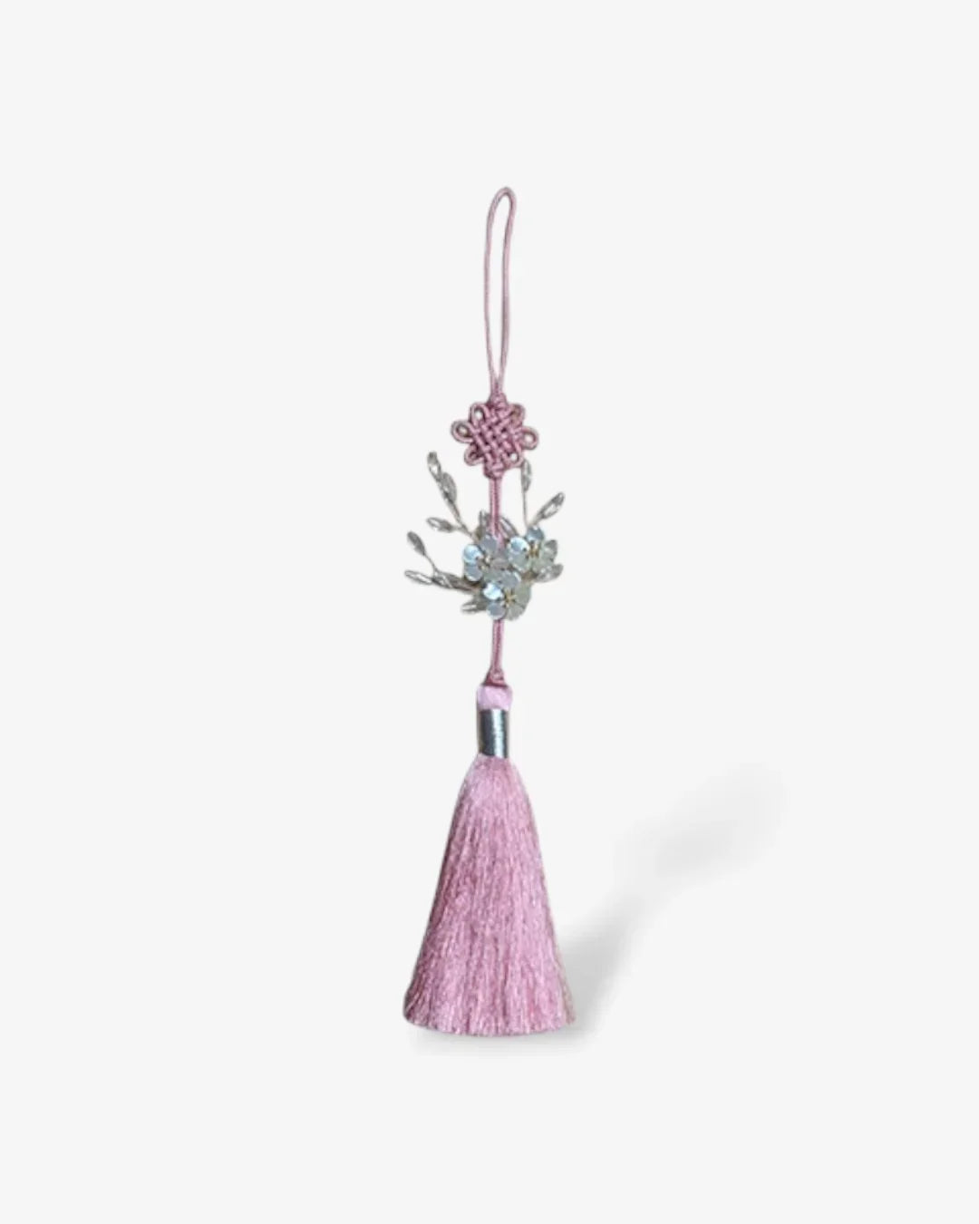 Pink norigae tassel with floral bead decoration and traditional knot on white background
