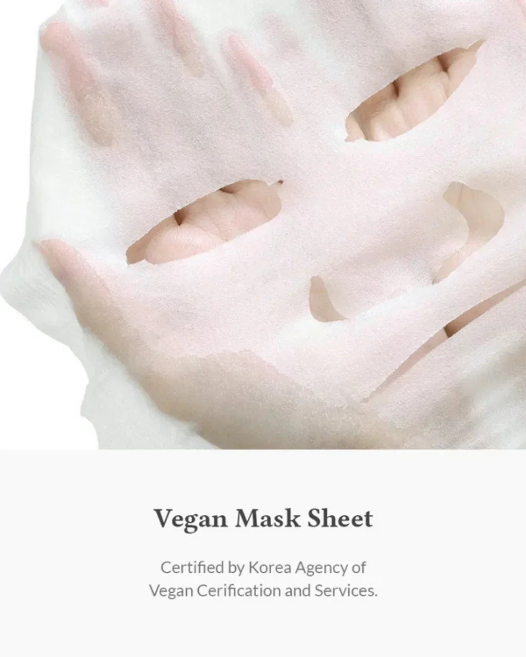 Hand holding a white vegan facial mask sheet with eye, nose, and mouth cutouts