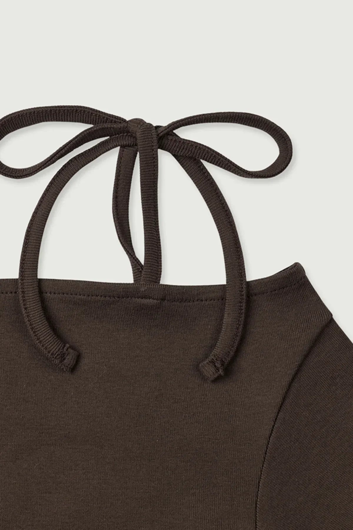 Close-up of brown off-shoulder long sleeve top with back tie detail on white background