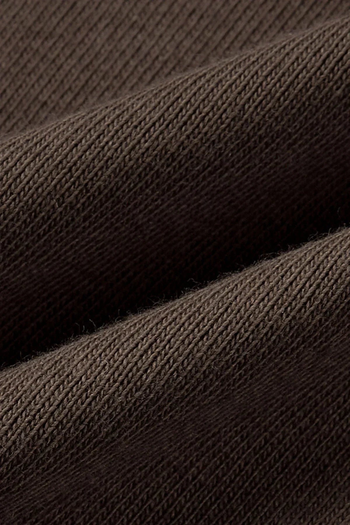 Close-up of brown ribbed knit fabric with detailed texture and folds