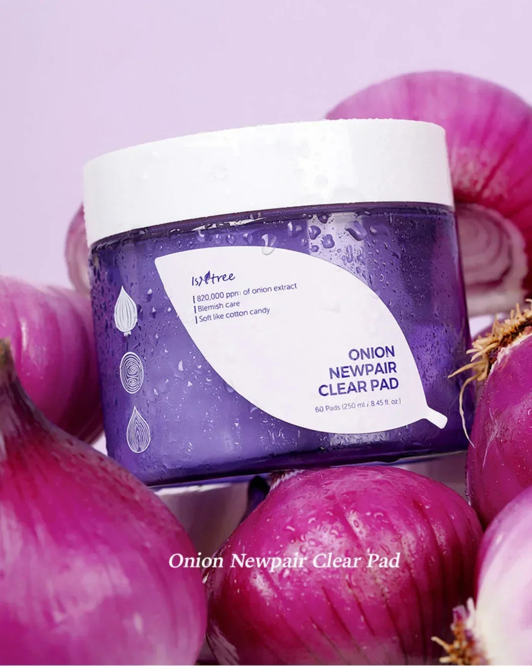 Isntree Onion Newpair Clear Pad skincare jar surrounded by fresh red onions on light purple background
