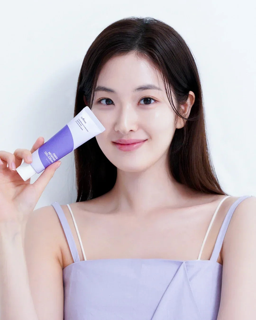 Smiling woman holding a lavender and white tube of Onion Newpair Gel Cream skincare product