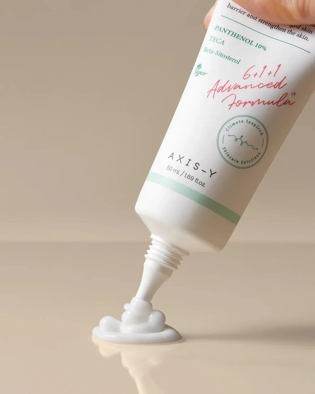 Axis-Y Panthenol 10% skin cream tube dispensing white moisturizing lotion on beige surface