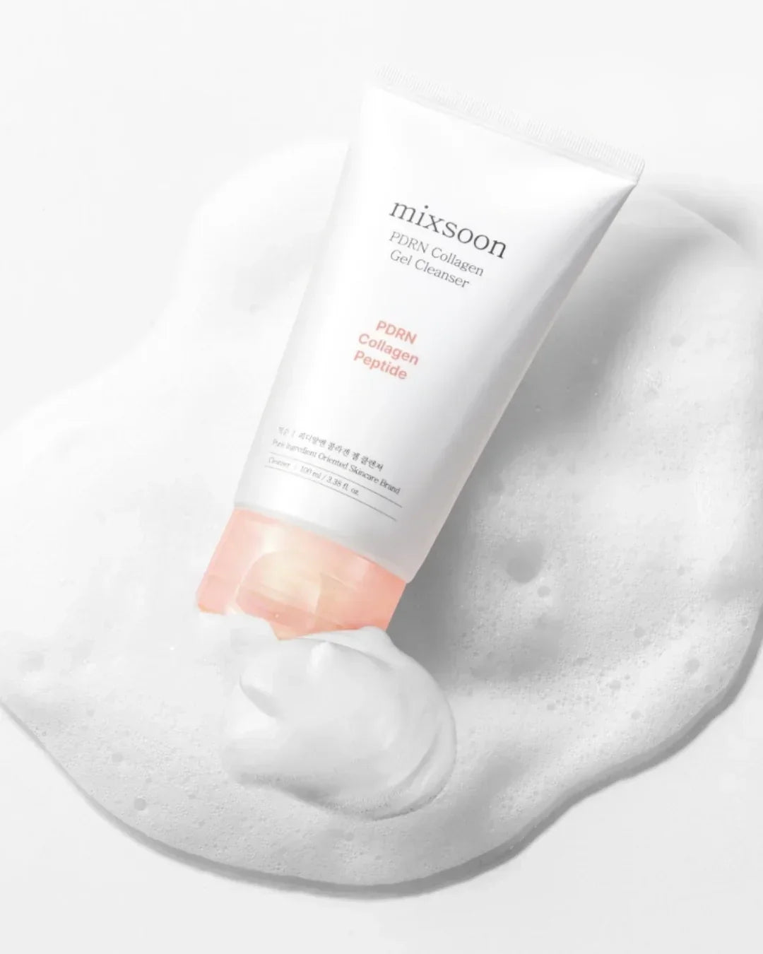 Mixsoon PDRN collagen gel cleanser tube on foam background with soft pink cap