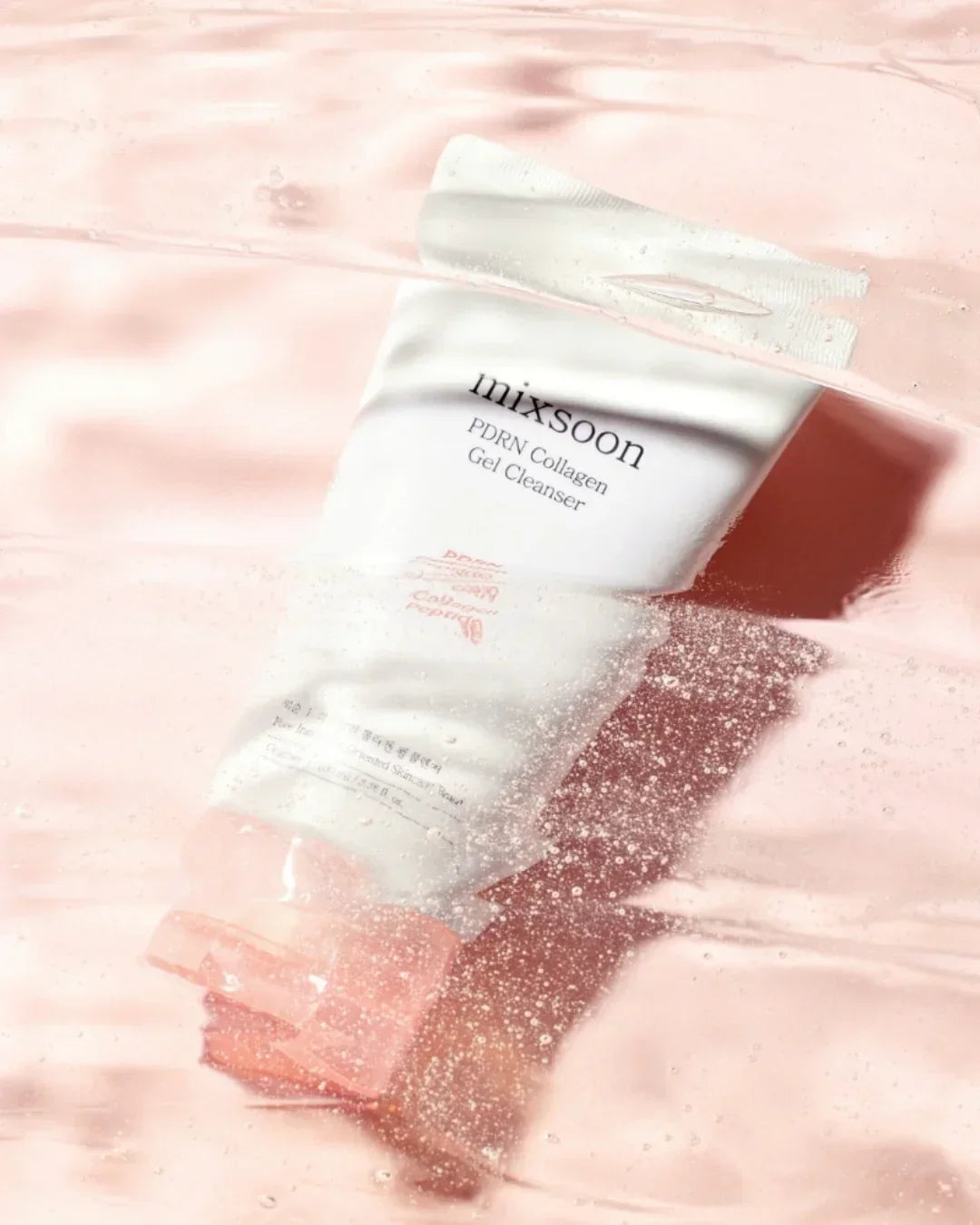 Mixsoon PDRN Collagen Gel Cleanser tube submerged in pink gel texture with bubbles