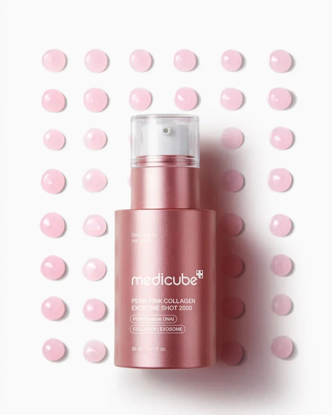 Medicube PDRN Pink Collagen Exosome Shot serum bottle and pink serum drops on white background