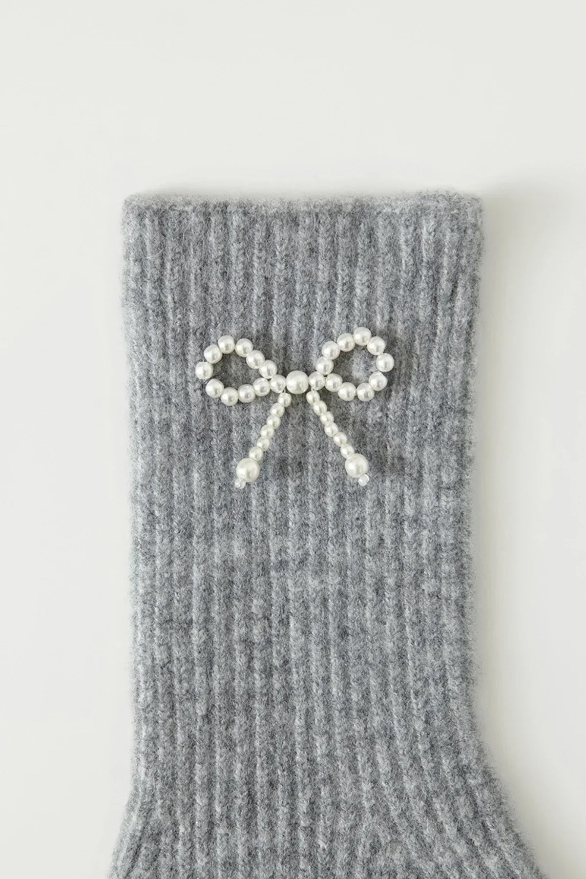 Gray ribbed knit fabric with decorative pearl ribbon bow embellishment