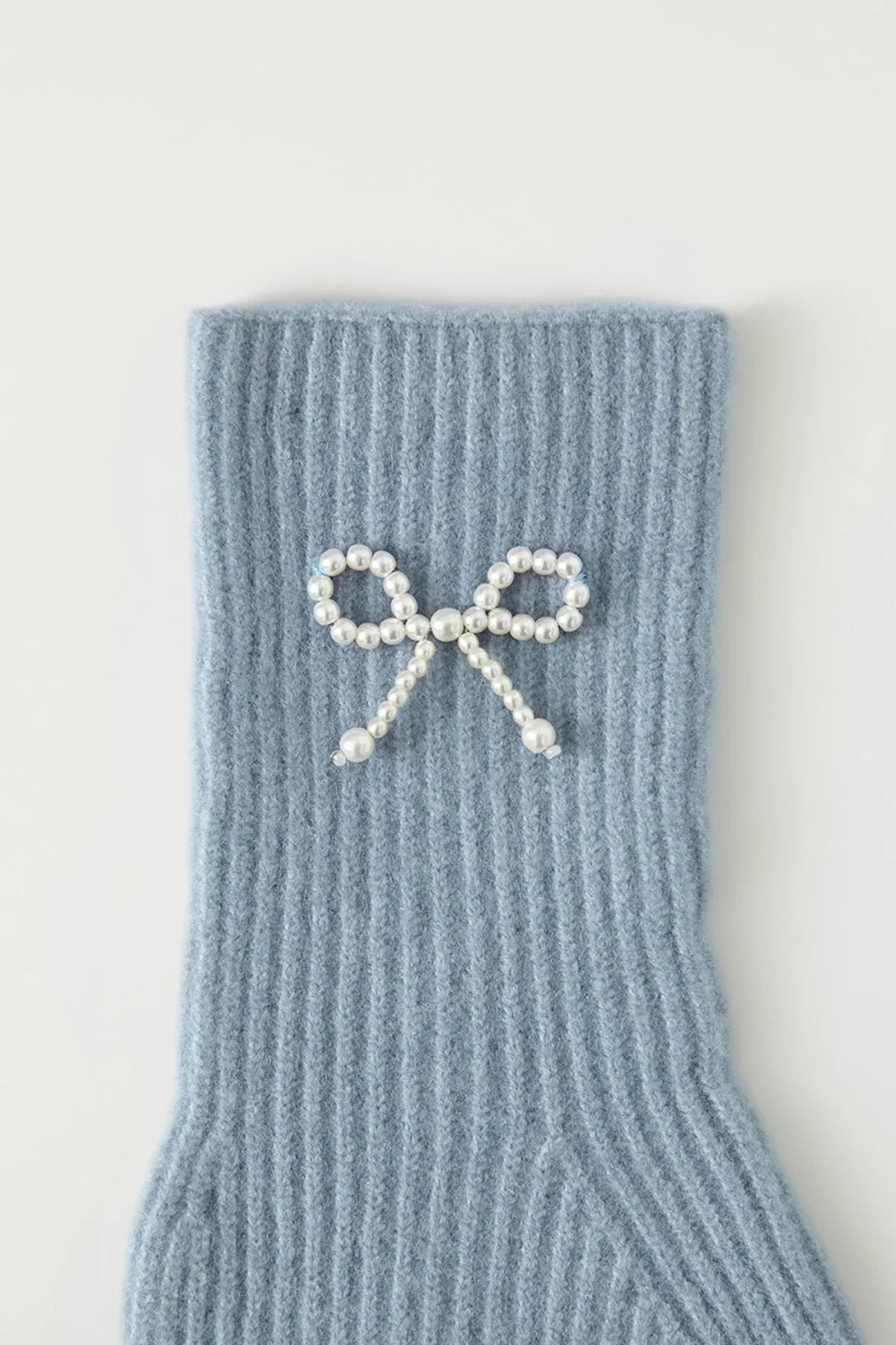 Light blue ribbed knit glove cuff with pearl bead bow decoration