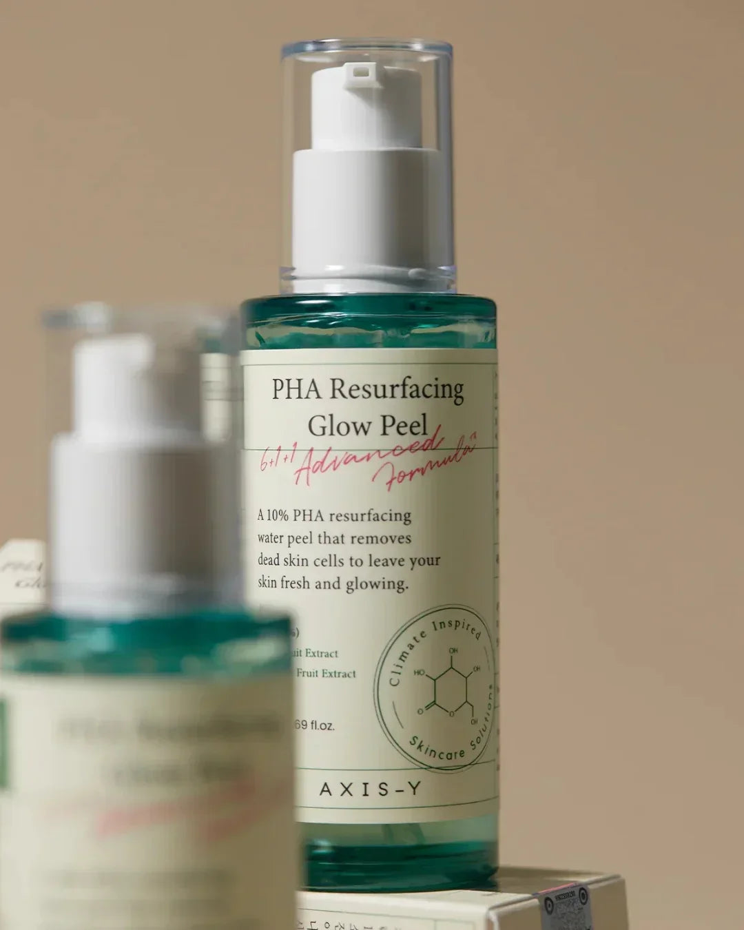 Bottle of Axis-Y PHA Resurfacing Glow Peel with white pump and label against beige background