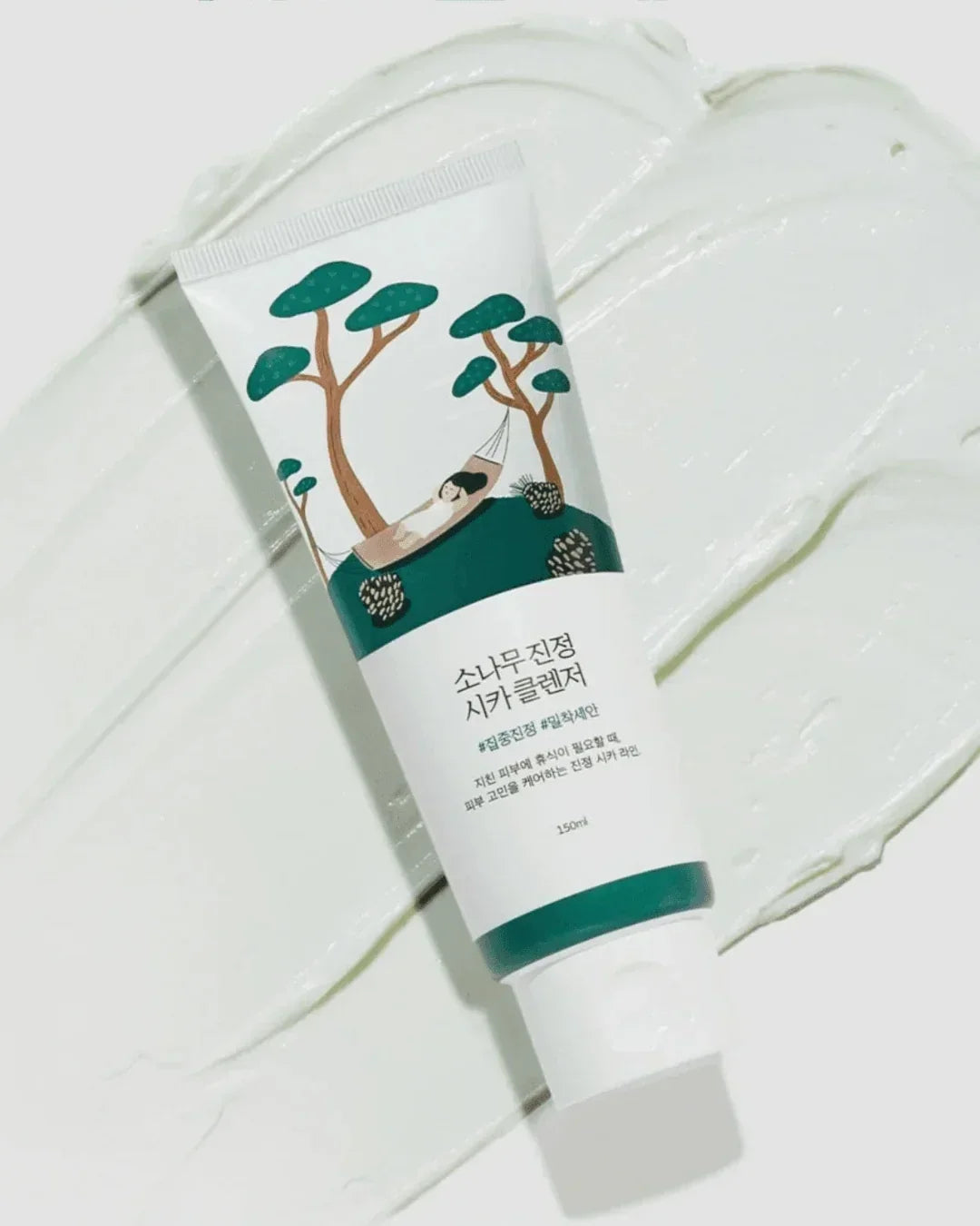 Pine calming cica cleanser tube with illustrated trees and hammock on white cream background