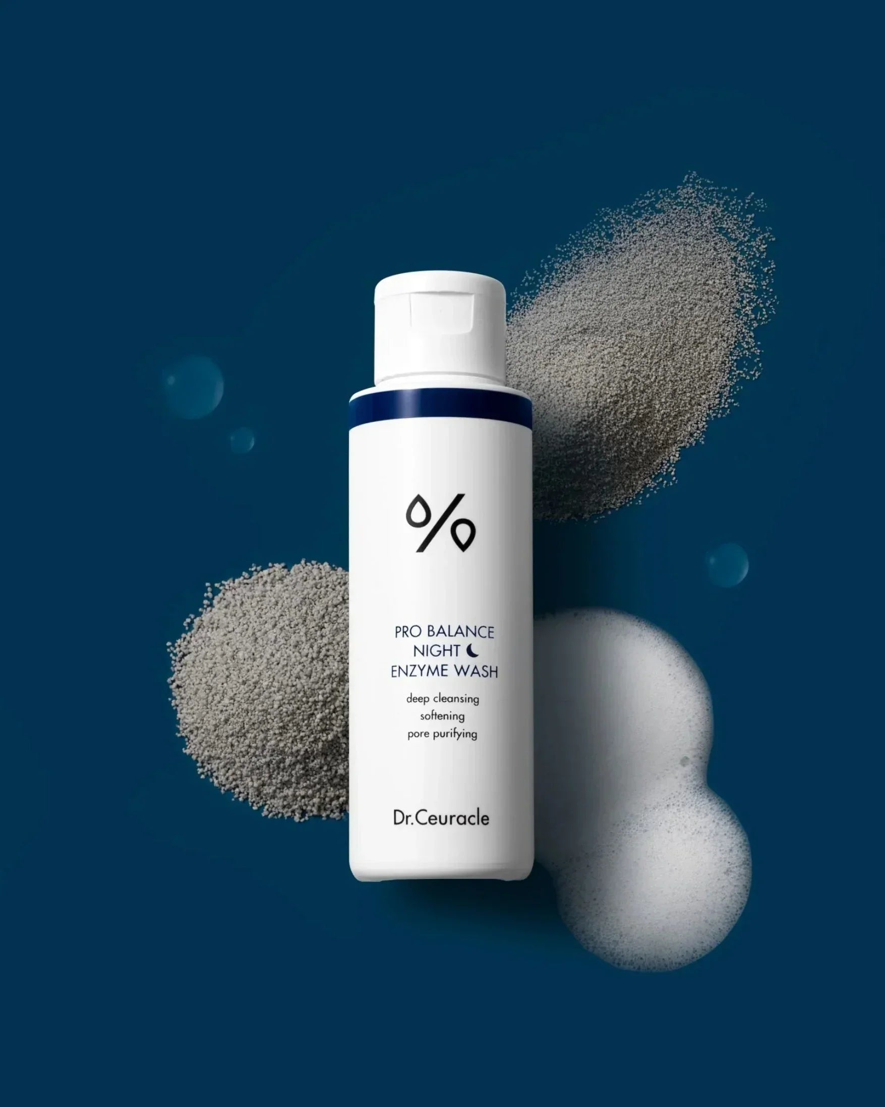 Dr.Ceuracle Pro Balance Night Enzyme Wash bottle on blue background with foamy bubbles and powder