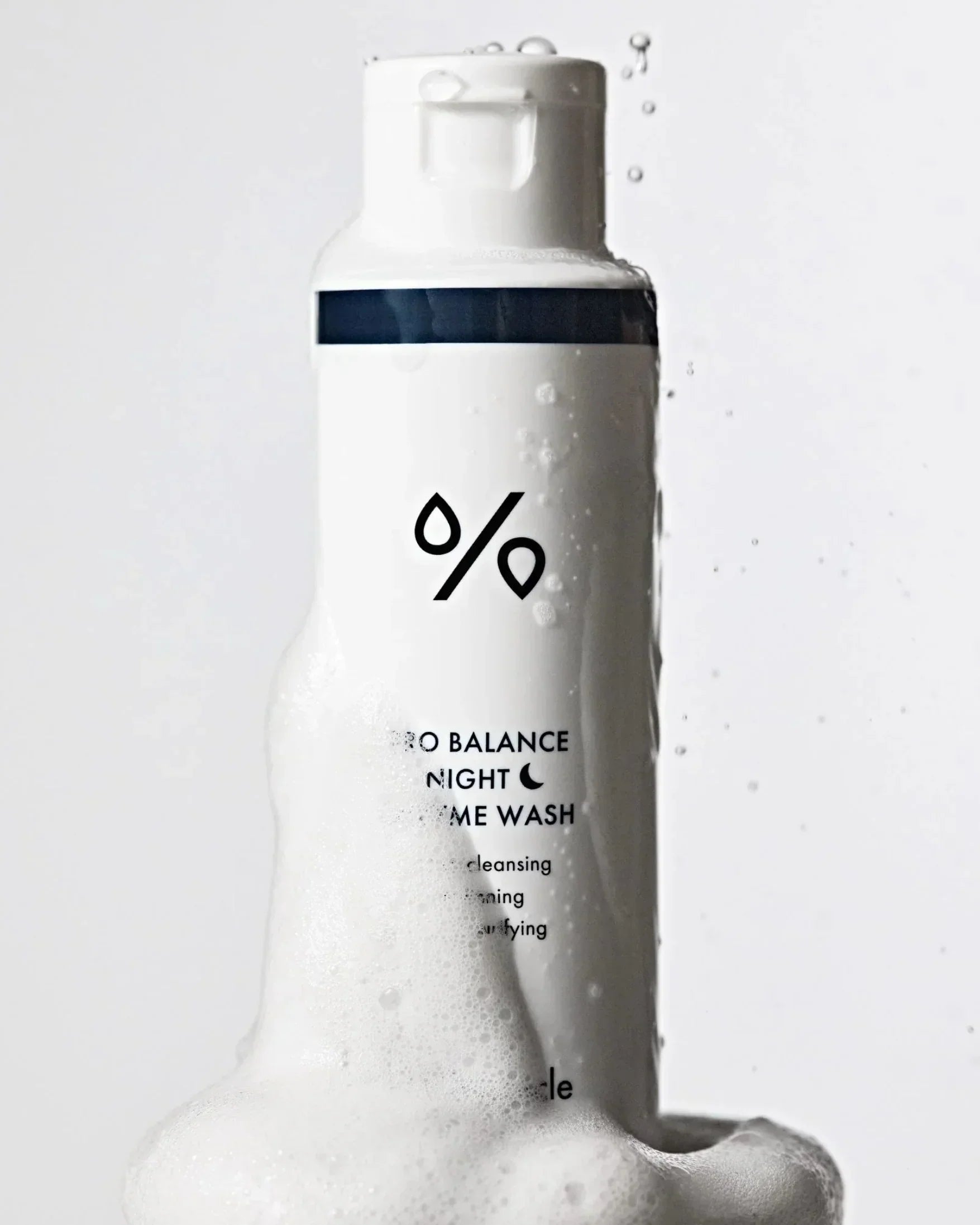 White bottle of Pro Balance Night Enzyme Wash with foam bubbles against white background