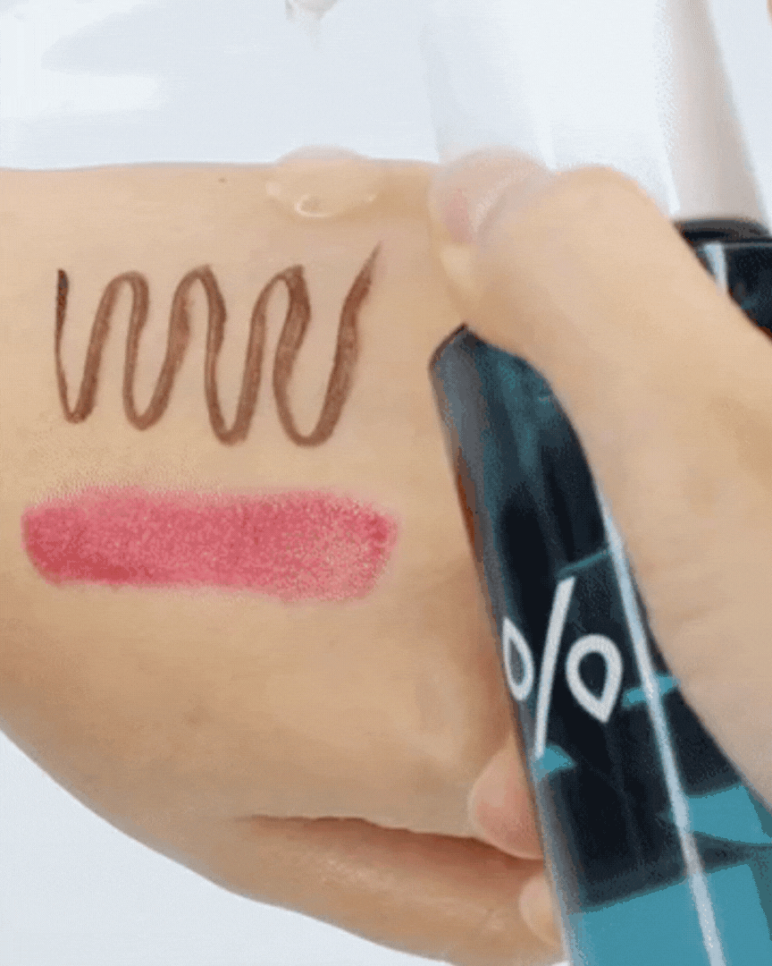 Hand testing Pro Balance Pure Cleansing Oil removing brown eyeliner and red lipstick swatches on skin