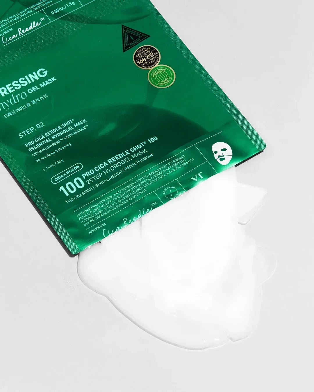Green Cica Reede Shot hydrogel mask package with white gel mask spilled out on white surface