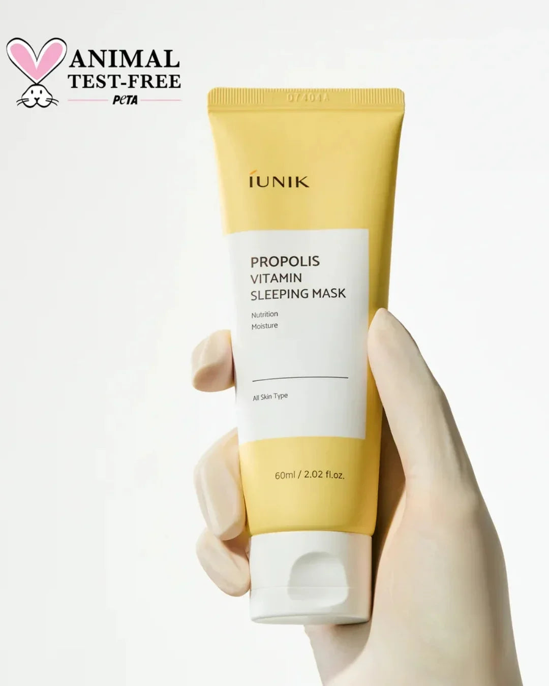 Hand holding iUNIK Propolis Vitamin Sleeping Mask tube with animal test-free PETA logo