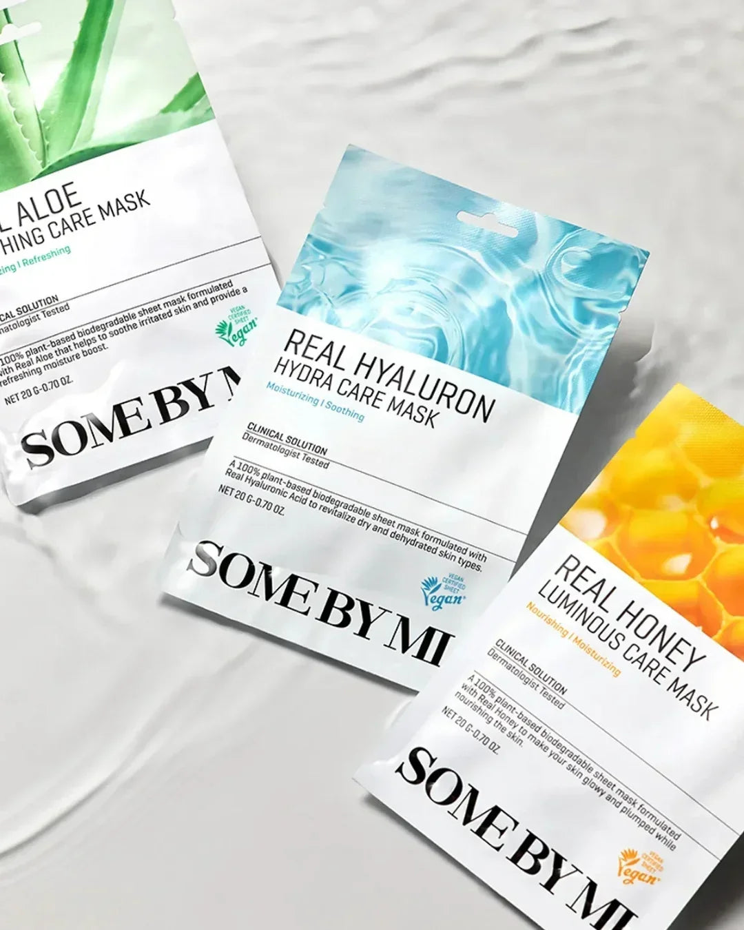 Three Some By Mi skincare masks on textured white surface: Real Aloe, Real Hyaluron, and Real Honey