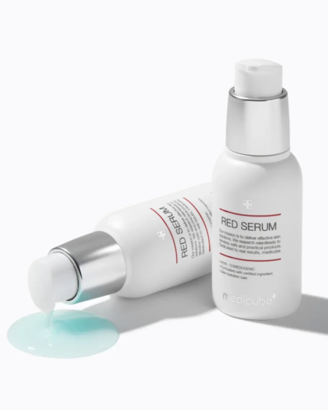 Medicube Red Serum 30ml bottle with silver pump and blue serum texture spilled on white background