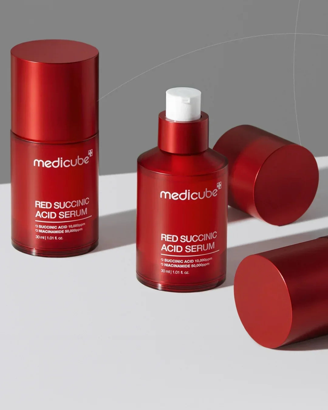 Medicube Red Succinic Acid Serum 30ml bottles with red caps on gray and white background