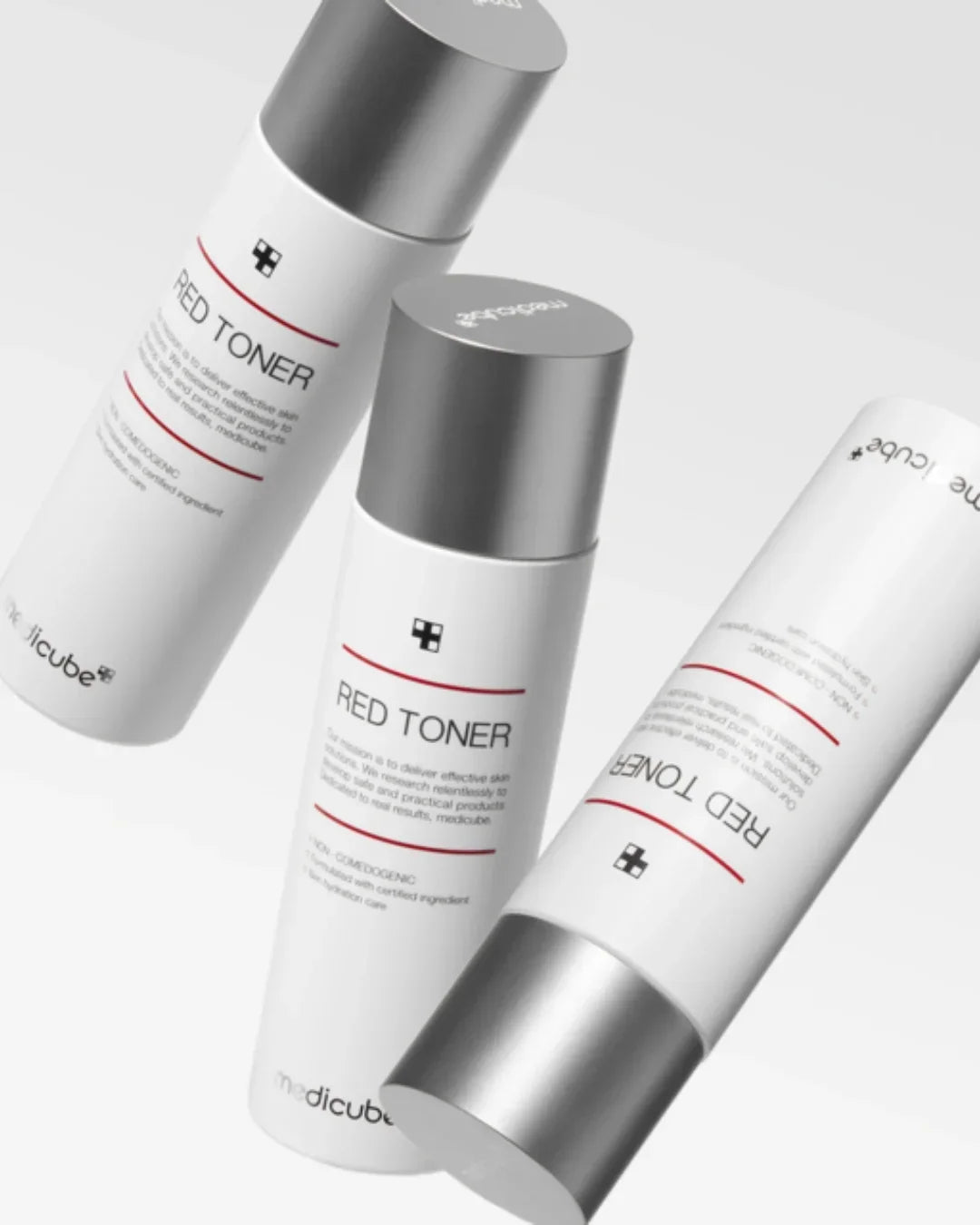 Three white bottles of Medicube Red Toner with silver caps on a white background
