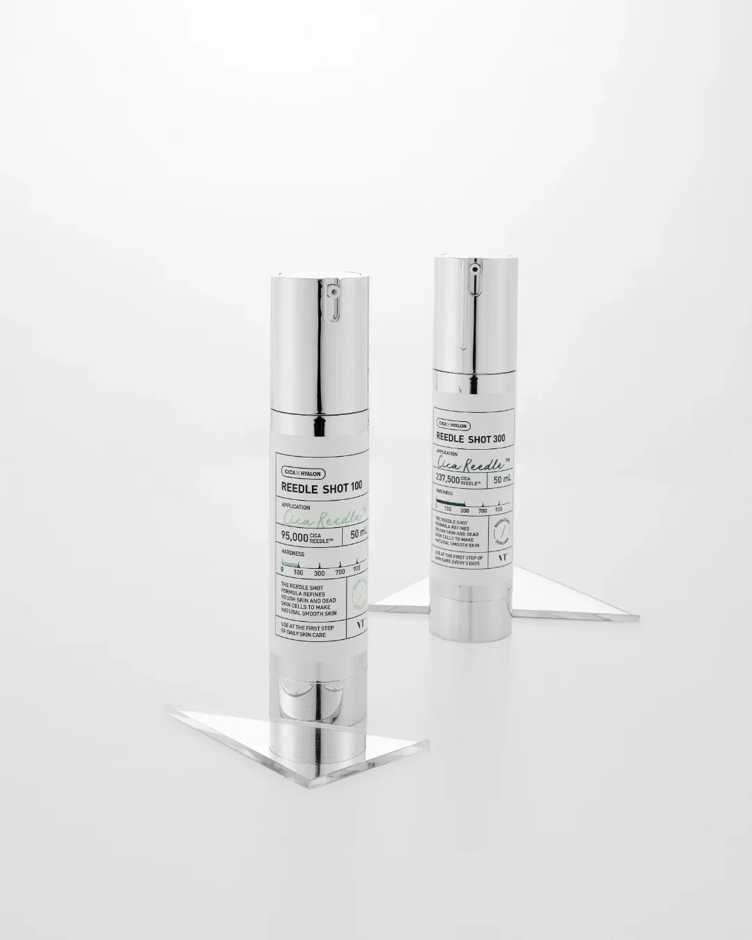 Two silver serum bottles labeled Reedle Shot 100 and Reedle Shot 300 on clear stands against white background