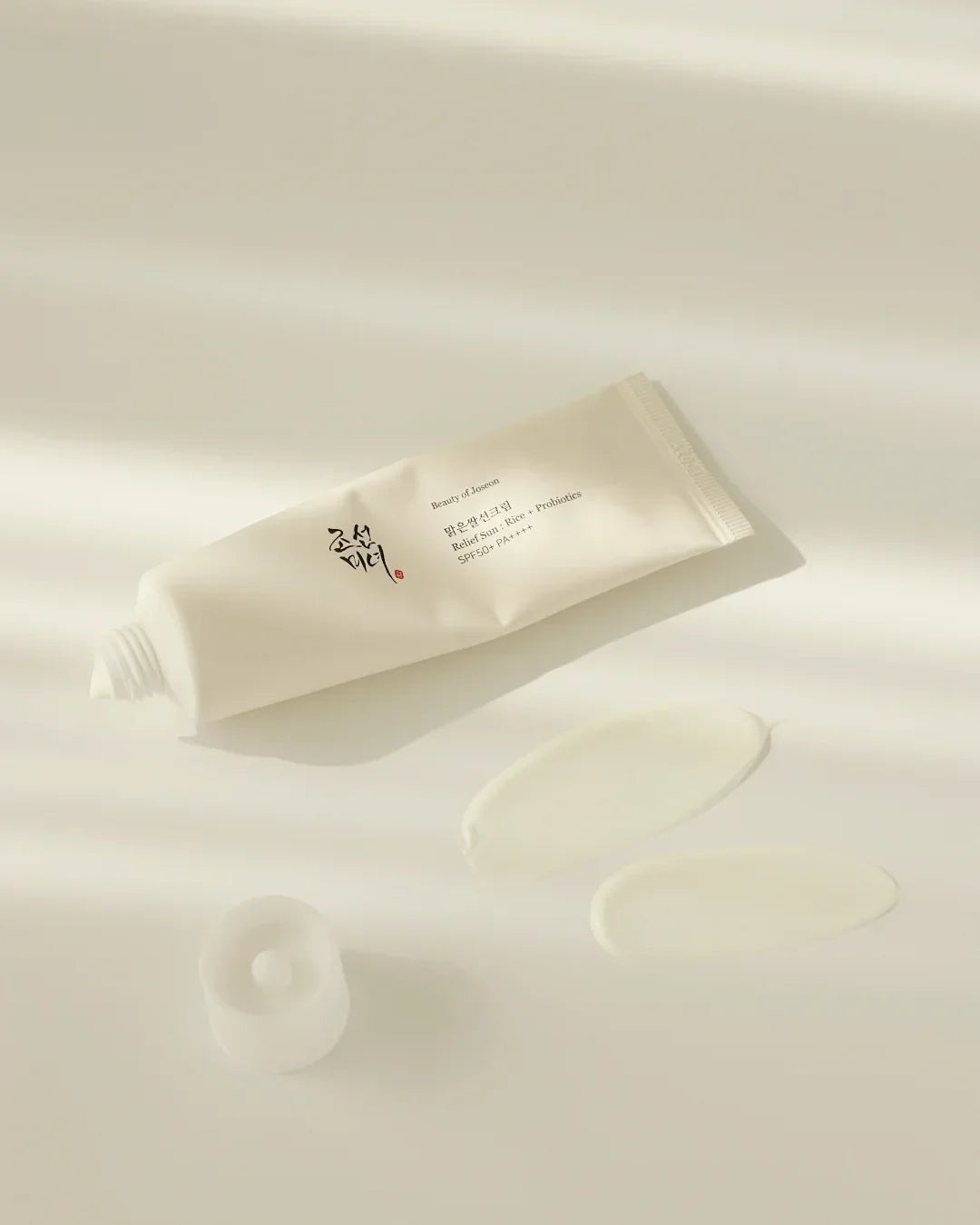Beauty of Joseon Relief Sun Rice Probiotics SPF50+ PA++++ sunscreen cream tube with swatched product on white surface