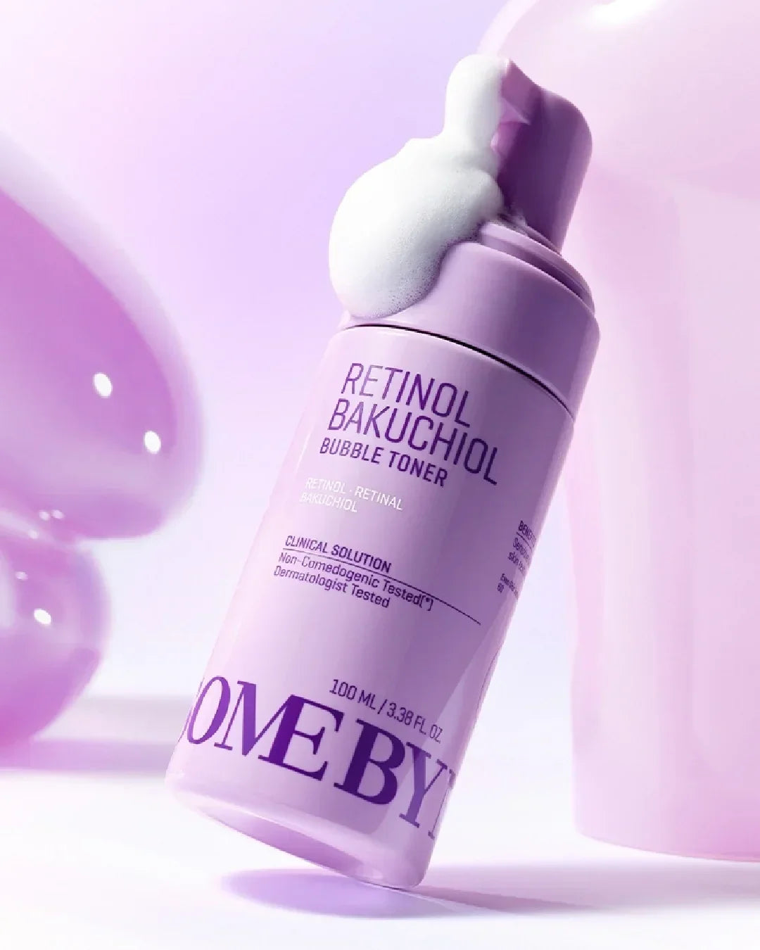 Purple bottle of Retinol Bakuchiol Bubble Toner with foam on top against pink background