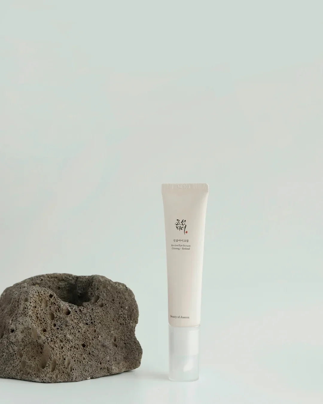 Tube of Beauty of Joseon Revive Eye Serum with Ginseng and Retinal, next to textured volcanic rock